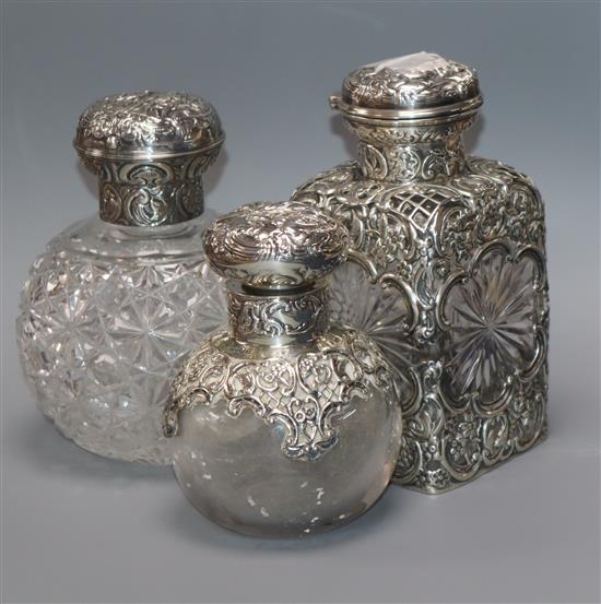 Three assorted Victorian/Edwardian silver mounted cut glass scent bottles by William Comyns & Sons, largest 14.5cm